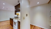 Located at 305 Euclid Ave in Oakland's desirable 94610 neighborhood, this single-floor residence combines classic charm with functional design throughout its thoughtfully laid-out spaces. Warm-toned hardwood flooring flows seamlessly across the open living and kitchen areas, creating a cohesive and inviting atmosphere.

The expansive living area is a standout, featuring recessed lighting, a classic brick fireplace, and a large sliding glass door that opens to a private balcony with views of the surrounding greenery, allowing abundant natural light to fill the space.

The galley-style kitchen is generously proportioned, offering rich dark-wood cabinetry — including upper cabinets with distinctive diamond-paned glass doors — granite-look countertops, and white appliances including a range, dishwasher, and refrigerator. A peninsula provides additional counter space and separation from the living area. The kitchen also connects to a walk-in pantry or storage closet, adding practical convenience.

The bathroom is clean and bright, finished with marble-style tile flooring, a white vanity with a mirrored medicine cabinet, and a full soaking tub and shower combination. The light, neutral palette throughout the home contributes to an open and airy feel across every room.
