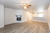 This single-story home in Lubbock, Texas offers a well-designed, open layout with consistent finishes throughout. The main living area is a spacious, open-concept space anchored by a white shiplap fireplace with a dark wood mantel, adding a striking focal point to the room. Wood-look luxury vinyl plank flooring runs throughout the main areas, complemented by recessed lighting and a ceiling fan overhead. The living space flows seamlessly toward the kitchen, which is defined by a peninsula-style breakfast bar ideal for casual dining or entertaining.

The kitchen is equipped with dark espresso cabinetry, speckled granite-style countertops, and a suite of black appliances including a refrigerator, electric range, and built-in microwave. A window provides natural light, brightening the workspace. The bedrooms feature plush carpeting, ceiling fans, and windows with blinds that allow in generous daylight.

The bathrooms are finished with dark espresso vanity cabinetry, granite-style countertops, bold-framed mirrors, and tub-shower combinations with built-in shelving. Wood-look flooring continues into the bathrooms, maintaining a cohesive aesthetic throughout the home.