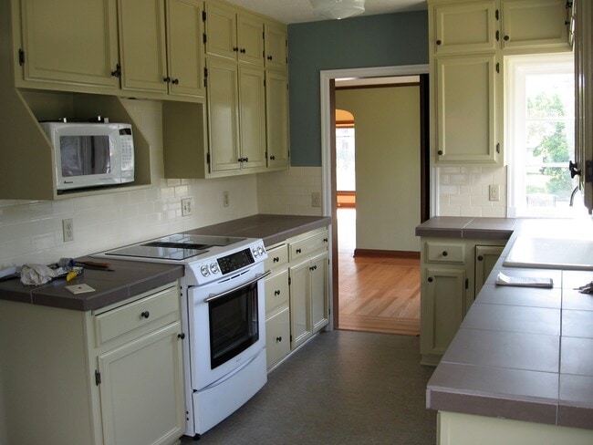 Front-facing kitchen with lots of windows and a dining nook. range, oven, microwave and fridge included. - 2910 NE Mason