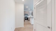 Located on Moreland Avenue SE in Atlanta, GA, this thoughtfully designed 1-bedroom, 2-bathroom residence offers a clean, contemporary aesthetic throughout its efficiently arranged single-level floor plan. Light-toned hardwood-style flooring runs continuously through the space, creating a cohesive and bright atmosphere.

The open-concept kitchen serves as a central highlight, featuring granite countertops, a large central island with seating potential, taupe flat-front cabinetry with open shelving, a white subway tile backsplash, and a full suite of stainless steel appliances including a refrigerator, range, microwave, and dishwasher. The kitchen flows naturally into the living area, making it ideal for everyday living and entertaining.

The bedroom is a well-proportioned, light-filled room with large windows offering neighborhood views, a ceiling fan, and access to a generously sized walk-in closet outfitted with wire shelving. Two full bathrooms provide added convenience, featuring granite-topped vanities and modern finishes.

A dedicated laundry area accommodates a full-size washer and dryer, adding practical functionality to the home. A hallway connects the rooms with clean sightlines, contributing to the overall sense of openness. Recessed lighting and white walls complete the fresh, modern character of this well-appointed residence.