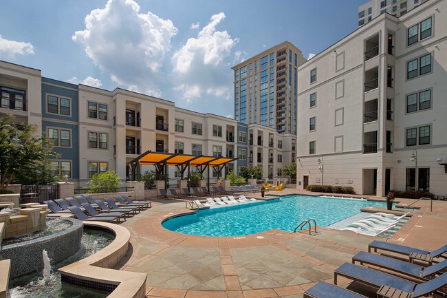 Piscina con asientos tipo lounge dentro del agua y secos, fuente y asientos cubiertos. - Elle of Buckhead