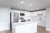 Located at 185 N West Temple in Salt Lake City, UT, this thoughtfully designed 3-bedroom, 2-bathroom residence offers a clean, modern aesthetic throughout its single-floor layout. The open-concept kitchen and living area serves as the heart of the home, anchored by a large central island with white quartz countertops, shaker-style white cabinetry, a classic subway tile backsplash, and a full suite of stainless steel appliances including a refrigerator, electric range, over-the-range microwave, and dishwasher. Light oak-toned hardwood flooring flows seamlessly throughout the entire space, enhancing the bright and airy atmosphere created by recessed lighting. The living area is bathed in natural light through expansive floor-to-ceiling sliding glass doors that open to a private balcony showcasing striking views of the Salt Lake City skyline. Each of the three bedrooms offers a comfortable, well-proportioned layout with large windows framing views of the surrounding cityscape and neighborhood. The primary bedroom includes a spacious double-door closet. Both bathrooms are finished in a crisp, contemporary style with white vanities, quartz countertops, backlit mirrors, and light hardwood flooring. The full bathroom features a tub-shower combination with subway tile surround and brushed nickel fixtures throughout.