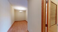 Located at 633 Main St NW in Elk River, Minnesota, this well-appointed one-bedroom, one-bathroom residence offers a thoughtfully designed single-floor layout. The open-concept kitchen and living area serves as the heart of the home, anchored by warm hardwood-style flooring that runs throughout. The kitchen is outfitted with rich wood cabinetry, dark granite countertops, a central island with a built-in sink, and a full suite of stainless steel appliances including a French door refrigerator, electric range, and microwave. Pendant lights and track lighting add both style and practicality to the space. The living area is bright and airy, highlighted by a sliding glass door that opens to a private balcony overlooking lush, tree-lined greenery — filling the room with natural light. The generously sized bedroom features plush carpeting, a dedicated closet, and a window framing outdoor views. The bathroom is finished with large-format tile flooring, a wood-toned vanity with ample storage, and a grab bar for added accessibility. A dedicated laundry room with a full-size washer and dryer completes this functional and comfortable home.