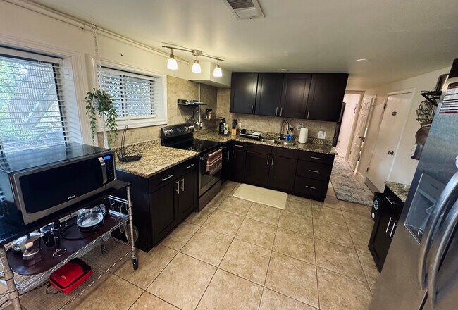 Amplio espacio de cocina para tres huéspedes, refrigerador completo, estufa de tamaño completo y microondas. - 11116 Kensington Ave