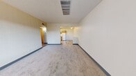 Located at 1429 Zepol Rd in Santa Fe, NM, this single-floor residence offers a practical and well-organized layout across two bedrooms, one bathroom, a living room, kitchen, and hallway. The living room is an open, carpeted space with a textured ceiling and overhead ventilation, flowing seamlessly toward the kitchen area. The kitchen is equipped with natural wood cabinetry, white appliances including a refrigerator, electric range, and dishwasher, complemented by light-toned vinyl plank flooring and a double-basin sink with ample counter space. The primary bedroom is a generously sized carpeted room featuring a large window with vertical blinds that invite natural light, while the second bedroom offers a similarly bright and comfortable layout with its own windowed wall. Both bedrooms feature neutral wall tones and blue-accented baseboards consistent throughout the unit. The bathroom includes a full tub-shower combination with white tile surround, a wood-accented vanity with a single sink, and vinyl plank flooring. The hallway connects the rooms efficiently, contributing to the cohesive and functional flow of the overall floor plan.