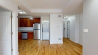 Located in Chicago's Rogers Park neighborhood, this 2-bedroom, 2-bathroom unit offers a well-designed layout across a single floor. Warm hardwood flooring flows throughout the main living areas, complementing the neutral gray and white walls that give the space a clean, modern feel.

The open kitchen is a standout, featuring rich wood cabinetry, granite countertops, and a full suite of stainless steel appliances including a gas range, microwave, dishwasher, and refrigerator. An in-unit stacked washer and dryer is conveniently tucked just off the kitchen area.

The living room is bright and airy, with a ceiling fan and sliding glass doors that open to a private balcony overlooking the surrounding neighborhood, allowing for excellent natural light. Both bedrooms are comfortably sized with hardwood floors, ceiling fans, and ample closet space. The second bedroom features a large window with outdoor views.

The two bathrooms are finished with neutral tile work. The primary bath includes a jetted soaking tub with full tile surround, while the second bathroom offers a tub-shower combination with tile walls and tile flooring. A dedicated utility room and additional closets provide practical storage throughout the unit.