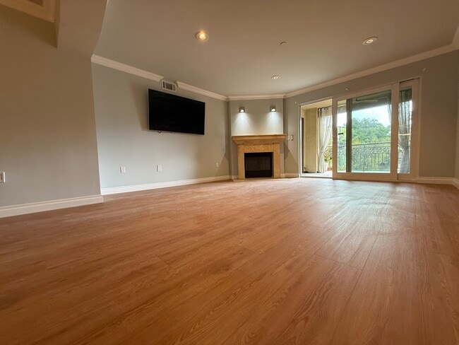 Sala de estar con chimenea de travertino - 6221 Monterey Rd