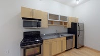 Located at 60 E Spring St in Columbus, Ohio, this two-floor space offers a functional and modern layout with a clean, contemporary aesthetic throughout. The main living area features light hardwood flooring that enhances the sense of openness, while upper-level rooms are finished with plush carpeting for added comfort.

The kitchen is well-appointed with light maple cabinetry, frosted glass upper cabinet accents, granite-style countertops, and a full suite of stainless steel appliances including a gas range, built-in microwave, dishwasher, and refrigerator. A stainless steel sink and ample counter space make the kitchen both practical and visually appealing.

The carpeted bedrooms are generously proportioned, with one featuring a large multi-pane window that allows abundant natural light and provides views of the surrounding urban landscape. Track-style ceiling hardware is also present, offering flexible lighting options.

The bathrooms are finished with granite countertops, undermount sinks, and tub-shower combinations with chrome fixtures and curved shower rods. Tile flooring and wall-mounted lighting complete the clean, utilitarian design.

Additional highlights include a half bath with a large mirror and wall sconce, and an open lower-level area with hardwood floors suited for flexible use. Overall, the space presents a well-maintained, move-in-ready environment in a prime downtown Columbus location.