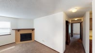 Located at 9211 E Harry St in Wichita, Kansas, this single-story home offers a practical and comfortable layout with consistent finishes throughout. The living room serves as a welcoming focal point, anchored by a corner fireplace with a tile surround and wood mantel, set against neutral white walls and wall-to-wall carpeting. Natural light filters in through the windows, enhancing the open feel of the space.

The galley-style kitchen is well-appointed with warm wood cabinetry lining both walls, light laminate countertops, a double basin sink, and black appliances including a refrigerator, microwave, and dishwasher. Tile flooring runs through the kitchen, adding durability to the functional space.

The bedrooms are carpeted and bright, each featuring ceiling fans with light fixtures and windows that bring in natural light. The rooms offer a clean, neutral palette suitable for a variety of uses.

The bathrooms are finished with tile flooring, wood vanity cabinetry, and light-toned countertops. The full bathroom includes a tub-shower combination, toilet, and a large vanity mirror with overhead lighting. A secondary bathroom provides convenient access from the hallway.

Textured ceilings are consistent throughout the home, and dark wood trim door frames add a classic contrast to the light walls, contributing to a cohesive and functional interior.
