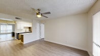 Located at 5150 W Eugie Ave in Glendale, Arizona, this single-floor, two-bedroom, two-bathroom residence offers a practical and well-appointed layout. The open-concept living room and kitchen area is anchored by light wood-style plank flooring and a ceiling fan with integrated lighting, creating a bright and airy atmosphere. Neutral-toned walls throughout complement the clean, modern aesthetic. The kitchen features a galley-style design with two-tone cabinetry — white uppers and dark grey lowers — paired with white quartz countertops, stainless steel appliances including a refrigerator, dishwasher, and range, as well as a skylight-style overhead fixture that fills the space with natural light. Each bedroom offers a comfortable footprint, with the primary bedroom providing additional space and its own dedicated closet. Both bedrooms feature ceiling fans and direct access to a closet and bathroom. The two bathrooms are clean and functional, each equipped with a full tub-shower combination, brushed nickel fixtures, and light wood-style flooring. A connecting hallway provides smooth flow between all rooms. The textured ceilings are consistent throughout, tying together the cohesive, move-in-ready design of this Glendale home.