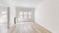 Located at 2528 Overlook Rd in Cleveland Heights, Ohio, this 2-bedroom, 1-bathroom home combines classic architectural character with functional living spaces across a single floor. Warm hardwood floors run throughout, lending a cohesive and timeless feel to every room.

The living room is a standout space, featuring a bay-style alcove with a bank of four diamond-pane windows that flood the room with natural light and offer leafy outdoor views. A classic cast-iron radiator anchors the space, adding to the home's vintage charm. An arched doorway connects the living area to the rest of the home.

The dining room provides a seamless transition between the living and kitchen areas, continuing the hardwood flooring and clean white walls. The kitchen is well-appointed with gray cabinetry, a mosaic tile backsplash, a stainless steel refrigerator, and a gas range, offering both style and practicality.

Both bedrooms are generously proportioned, with the primary bedroom offering a spacious layout, natural light, a ceiling fan, and a cast-iron radiator. The second bedroom also features hardwood floors and a ceiling fan. The full bathroom includes a single vanity and a tub-shower combination. Two hallways provide practical flow throughout the home, connecting all rooms efficiently.