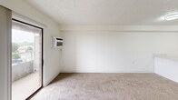 Located at 2345 Oxford Rd in Berkley, Michigan, this one-bedroom, one-bathroom unit offers an efficient and well-organized layout across a single floor. The combined kitchen and living area forms the heart of the space, with the kitchen showcasing white cabinetry, a marble-style countertop with a breakfast bar, stainless steel appliances including an electric range and refrigerator, and wood-look vinyl flooring. A textured ceiling and flush-mount lighting complete the kitchen's clean, modern aesthetic. The living area is carpeted and bright, featuring a sliding glass door that opens to a private balcony with outdoor views, complemented by vertical blinds and a wall-mounted air conditioning unit. The bedroom is a comfortable, carpeted retreat with a large window that brings in natural light, a built-in closet with sliding doors, and direct access to the rest of the unit. The full bathroom is finished with wood-look vinyl flooring, a white vanity, a tub/shower combination with white tile surround, and stainless steel accessibility grab bars for added safety and convenience. Throughout the unit, crisp white walls and textured ceilings create a clean, neutral backdrop that is both functional and easy to personalize.