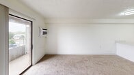 Located at 2345 Oxford Rd in Berkley, Michigan, this one-bedroom, one-bathroom unit offers an efficient and well-organized layout across a single floor. The combined kitchen and living area forms the heart of the space, with the kitchen showcasing white cabinetry, a marble-style countertop with a breakfast bar, stainless steel appliances including an electric range and refrigerator, and wood-look vinyl flooring. A textured ceiling and flush-mount lighting complete the kitchen's clean, modern aesthetic. The living area is carpeted and bright, featuring a sliding glass door that opens to a private balcony with outdoor views, complemented by vertical blinds and a wall-mounted air conditioning unit. The bedroom is a comfortable, carpeted retreat with a large window that brings in natural light, a built-in closet with sliding doors, and direct access to the rest of the unit. The full bathroom is finished with wood-look vinyl flooring, a white vanity, a tub/shower combination with white tile surround, and stainless steel accessibility grab bars for added safety and convenience. Throughout the unit, crisp white walls and textured ceilings create a clean, neutral backdrop that is both functional and easy to personalize.