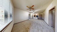 Located at 4652 Miramar Dr in St. Petersburg, FL, this well-appointed 2-bedroom, 2-bathroom single-floor residence offers a thoughtfully designed layout with a comfortable, neutral aesthetic throughout. The kitchen is a functional highlight, featuring granite countertops, light wood cabinetry, black appliances including a refrigerator and range, a double-basin sink, pendant lighting, and durable hardwood-style flooring. A peninsula counter opens toward the living area, which is accented by a charming built-in arched shelving nook — a distinctive architectural detail that adds character to the space. Both bedrooms are generously sized with plush carpeting, ceiling fans, and windows that bring in natural light. The primary bedroom is particularly spacious and connects to a dedicated bathroom and a walk-in closet outfitted with wire shelving. The second bedroom also benefits from good natural light and easy bathroom access. Each bathroom is finished with tile flooring, warm wood vanity cabinetry, dual sinks set in granite counters, large mirrors, and a tub/shower combo with tile surround. A hallway connects the rooms efficiently, and two dedicated closets provide ample storage throughout the residence.