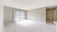 Located at 1225 Deerfield Pkwy in Buffalo Grove, IL, this single-floor, one-bedroom, one-bathroom residence offers a well-organized layout designed for comfortable everyday living. The entryway leads into a thoughtfully arranged floor plan that connects the main living areas with ease.

The living room is bright and inviting, featuring soft wall-to-wall carpeting in neutral tones and a large sliding glass door that fills the space with natural light while providing outdoor views. An adjacent dining area flows naturally into the kitchen, which is well-appointed with warm cherry wood cabinetry, quartz countertops, stainless steel appliances including a range, microwave, and refrigerator, and a peninsula with a built-in sink — ideal for both cooking and casual dining.

The bedroom is a comfortable, carpeted retreat with a window offering natural light and outdoor views. Three closets throughout the unit provide generous storage. The full bathroom features tile flooring, a wood vanity with a white countertop, a large mirror, and wall-mounted cabinetry for additional storage.

A dedicated laundry room with side-by-side washer and dryer units and overhead cabinetry adds everyday convenience, while a utility room rounds out the functional layout of this well-maintained residence.