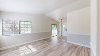 Located at 1164 E Perrin Ave in Fresno, California, this single-story, three-bedroom, two-bathroom home offers a well-organized layout with a clean, neutral aesthetic throughout. The kitchen and living room share an open-concept design, with the kitchen featuring white cabinetry, rich dark granite countertops, stainless steel appliances including a refrigerator and range, and light wood-style flooring that extends seamlessly into the adjacent living area. A peninsula-style counter divides the spaces, adding functionality and definition. The living area benefits from two-tone painted walls and abundant natural light streaming through large windows fitted with blinds. Two hallways connect the main living spaces to the bedrooms and bathrooms, ensuring an efficient flow. All three bedrooms are carpeted, bright, and windowed, offering comfortable natural light and outdoor views. The primary bedroom provides a generous footprint among the three. Both bathrooms feature tile flooring, white cabinetry, and granite-topped vanities. The primary bathroom includes a glass-enclosed walk-in shower, while the second bathroom offers a standard configuration. The home's consistent use of neutral tones, updated finishes, and practical layout makes for a cohesive and functional living environment.
