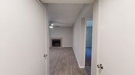 Located at 1700 Weatherly Drive in Stone Mountain, Georgia, this two-bedroom, three-bathroom single-floor residence offers a well-organized layout designed for comfortable everyday living. The open living room serves as the heart of the home, highlighted by a tile-surround wood-burning fireplace, a ceiling fan with light fixture, and wood-look laminate flooring that extends seamlessly into the adjacent dining area. Natural light filters in through window blinds, and a sliding door leads to a private balcony with outdoor views.

The galley-style kitchen is efficiently designed with white shaker cabinetry, dark granite-look countertops, a stainless steel sink, and black appliances including a range, dishwasher, and refrigerator. Track lighting overhead adds a practical touch.

Both bedrooms feature plush carpeting and textured ceilings. The primary bedroom includes a spacious walk-in closet outfitted with wire shelving across multiple levels, providing generous storage capacity. The secondary bedroom offers a window with outdoor views and access to the hallway.

All three bathrooms are appointed with white tile tub-shower combos, dark countertop vanities with white cabinetry, and wood-look flooring. The layout is completed by two hallways connecting each area of the home efficiently.
