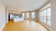 Located on State Street in Schenectady, NY, this single-floor 2-bedroom, 2-bathroom residence offers a thoughtfully designed layout with modern finishes throughout. The open-concept kitchen and living area serves as the heart of the home, featuring light hardwood-style flooring, recessed lighting, and an abundance of natural light from large double-hung windows. The kitchen is outfitted with gray shaker-style cabinetry, a white subway tile backsplash, stainless steel appliances, and a generous granite-topped island with elegant pendant lighting overhead — ideal for both cooking and casual dining. The spacious living area flows seamlessly from the kitchen, creating an inviting, airy atmosphere. A well-lit hallway with recessed lighting and crisp white panel doors connects the main living areas to the private quarters. Both bedrooms are carpeted with plush neutral-toned carpet and feature geometric flush-mount light fixtures. The generously sized primary bedroom includes a wide window framing outdoor views. The bathrooms are clean and functional, with one featuring a walk-in shower alongside a bright window. Two closets and two hallways round out the efficient, well-organized floor plan, making this residence as practical as it is comfortable.