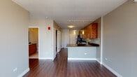 Located in the heart of Chicago's vibrant River North neighborhood, this high-rise unit at 215 W Huron St offers a modern, open-concept layout with an impressive array of upscale finishes. Rich hardwood flooring flows throughout the living areas, creating a warm and cohesive aesthetic against the neutral-toned walls.

The kitchen is thoughtfully designed with warm-toned wood cabinetry, dark granite countertops, a tile backsplash, and a full suite of stainless steel appliances including a gas range, microwave, and refrigerator. A peninsula with counter seating connects the kitchen to the open living area, making it ideal for both everyday living and entertaining. Pendant lighting and track lighting add functional style to the space.

The living area is a standout, anchored by expansive floor-to-ceiling windows that frame breathtaking panoramic views of the Chicago skyline, flooding the room with natural light. The bedroom similarly benefits from large windows offering elevated city views.

The bathroom is finished with large-format tile flooring, a wood vanity with granite countertop, and a full soaking tub with shower. A walk-in closet provides generous storage. The unit's layout is efficient and well-organized, with a dedicated entry corridor that transitions smoothly between spaces, offering both comfort and functionality in a prime urban setting.