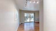 Located at 4900 Marconi Ave in Arden-Arcade, California, this thoughtfully designed unit offers an efficient and modern layout across a single floor. Warm hardwood-style flooring runs seamlessly throughout the entire space, lending a cohesive and inviting feel.

The dining area is bathed in natural light courtesy of a sliding glass door fitted with vertical blinds, which also provides access to an outdoor view. A wall-mounted HVAC unit ensures year-round climate comfort, while a track lighting fixture overhead delivers adjustable ambient illumination.

The kitchen is outfitted with stylish navy blue lower cabinetry accented by matte black hardware, contrasted by crisp white upper cabinets and a clean white countertop. A full-size stainless steel refrigerator anchors the space, completing a contemporary and functional cooking environment.

The bathroom continues the unit's modern aesthetic with a navy blue vanity topped by a white countertop and an undermount sink with a matte black faucet. A framed mirror above the vanity adds depth, while wood-look flooring ties the room to the rest of the unit. Louvered bifold doors provide a charming and practical entryway into the bathroom.

Overall, this unit presents a clean, updated interior with consistent modern finishes throughout.