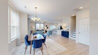 Located at 2005 Waterside Dr in Suffolk, Virginia, this two-story home offers a thoughtfully designed layout spread across two comfortable floors. The main level opens into a bright, open-concept living area where the dining room, living room, and kitchen flow seamlessly together. Light hardwood-style flooring runs throughout, complementing the neutral color palette and abundant natural light streaming in through large windows. The living room features a ceiling fan and generous space for seating, while the dining area is anchored by an elegant chandelier and large windows with outdoor views. The kitchen is a standout, boasting white cabinetry, granite countertops, stainless steel appliances, and a central island with bar seating — ideal for both cooking and entertaining. A dedicated laundry room with full-size washer and dryer adds everyday convenience. Upstairs, the primary bedroom is a spacious retreat highlighted by a tray ceiling with crown molding and ceiling fan. It is complemented by a walk-in closet with wire shelving. The additional bedrooms are bright and well-sized, each with natural light. The bathrooms are clean and modern, featuring white vanities, glass-enclosed showers, and light hardwood-style flooring. Three full bathrooms serve the home's three bedrooms comfortably.