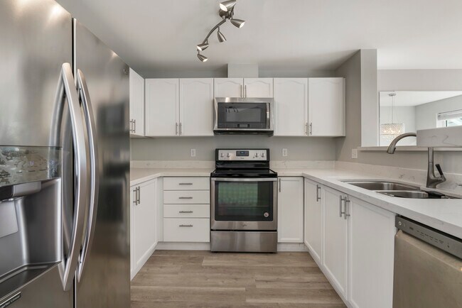 Kitchen with stainless steel appliances and quartz countertops - 9910 NE 137th St Apartment
