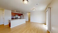 Located at 211 Sacandaga Rd in Schenectady, NY, this single-floor, 2-bedroom, 1-bathroom home offers a thoughtfully designed layout with a clean, modern aesthetic throughout. The open-concept kitchen and living area serves as the heart of the home, where rich dark-wood cabinetry, granite countertops, and a full suite of stainless steel appliances — including a gas range, microwave, and refrigerator — create a functional and stylish kitchen. A peninsula with a built-in sink provides additional prep space and naturally defines the transition into the bright, airy living room. Light hardwood-style flooring runs throughout the main living areas, complementing the neutral wall tones. The living room is filled with natural light courtesy of a sliding glass door and an adjacent window, offering outdoor views and easy access to the exterior. Both bedrooms feature plush carpeting and natural light from multiple windows, with the primary bedroom offering a generous footprint and a pleasant outdoor view. The full bathroom is finished with tile flooring, a granite-topped vanity, and accessibility-friendly grab bars. A dedicated laundry room houses a full-size washer, water heater, and HVAC system, adding everyday convenience to this well-rounded home.