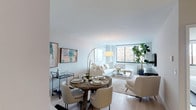 Located at 225 E 95th Street in the desirable Carnegie Hill neighborhood of Manhattan's Upper East Side, this thoughtfully designed residence offers a seamless single-floor layout that maximizes both functionality and comfort. The open-concept living and dining area serves as the heart of the home, featuring light hardwood floors, crisp white walls, and large windows that flood the space with natural light while framing views of the surrounding cityscape. The living area provides ample room for relaxed seating and entertainment, while a dedicated dining space accommodates a full table with ease. The kitchen is efficiently designed with white cabinetry, stainless steel appliances including a gas range and built-in microwave, and light countertops — along with a convenient pantry closet for additional storage. The bedroom is a tranquil retreat, highlighted by textured accent wallcovering, light hardwood flooring, a large window with city views, and a generous double closet with bifold doors. The bathroom features clean, neutral tile work with a full soaking tub and overhead shower. Throughout the residence, a cohesive palette of soft neutrals and natural materials creates a calm, contemporary ambiance well-suited to urban living.