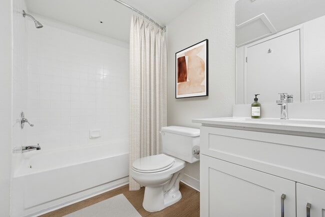 Renovated Package II bath with white cabinetry, quartz countertop, and hard surface flooring - eaves Walnut Creek