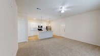 Located at 2151 W Moore St in Sherman, TX, this single-story 2-bedroom, 2-bathroom home offers a well-designed, functional layout with modern finishes throughout. The open-concept kitchen and living area serves as the heart of the home, featuring a central island with granite countertops, a undermount sink, and pendant lighting. White shaker-style cabinetry, a subway tile backsplash, and stainless steel appliances — including a refrigerator, range, and microwave — complete the kitchen. A pantry provides additional storage. The living area is finished with plush carpet and a ceiling fan, with a door leading to an outdoor space. Both bedrooms are carpeted and generously sized, with the primary bedroom offering a walk-in closet equipped with wire shelving. The second bedroom benefits from dual windows that bring in natural light. Both bathrooms feature granite-topped white vanities and wood-look flooring. One bathroom includes a tiled tub-shower combination. A dedicated laundry room and utility room add convenience. Neutral tones and clean white walls create a bright, cohesive ambiance throughout the home.