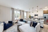 Located in Atlanta's vibrant Midtown neighborhood, this thoughtfully designed 2-bedroom, 3-bathroom residence offers a seamless open-concept layout with modern finishes throughout. Light wood-look flooring flows across the single-level floor plan, connecting each space with a cohesive, contemporary aesthetic.

The living room is bright and inviting, with large windows dressed in neutral linen drapes that allow abundant natural light and views of the surrounding neighborhood. It transitions effortlessly into the dining area and kitchen, creating an ideal space for entertaining.

The kitchen is a standout feature, boasting white upper cabinetry with gold hardware, contrasting dark wood lower cabinets, sleek quartz countertops, stainless steel appliances, and a central island with bar seating illuminated by stylish pendant lighting.

Both bedrooms are comfortably scaled and filled with natural light from large windows. The primary bedroom includes a walk-in closet with built-in shelving and organizers. Bold dark-paneled doors add a dramatic design touch throughout the unit.

The three bathrooms are finished with marble-style tile, modern vanities with quartz countertops, and tub-shower combinations. The overall ambiance is clean, modern, and refined — ideal for urban living in the heart of Atlanta.