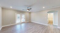 Located at 437 Roanoke Rd in Daleville, Virginia, this well-appointed single-floor home offers three bedrooms, two bathrooms, and a thoughtfully designed open-concept layout. The heart of the home is a seamless combination of kitchen, dining, and living areas bathed in natural light. The kitchen is a standout feature, showcasing grey shaker-style cabinetry, a white quartz countertop island with a deep single-basin sink, stainless steel appliances including a refrigerator with ice maker, range, and microwave, all accented by striking matte black pendant lighting. Light wood-look flooring flows throughout the main living areas, complemented by crown molding and recessed lighting that add a refined finish. The spacious living room opens via French doors to a private balcony, with a ceiling fan overhead enhancing comfort. The generously sized primary bedroom features plush carpet, a large picture window, and a ceiling fan. Additional bedrooms also include carpet flooring, ample closet space with double-door closets, and natural light. The two bathrooms are clean and modern, featuring grey vanities with white countertops. A dedicated laundry room with a full washer and dryer and a pantry add to the home's practical appeal.
