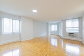 Located at 1477 Mississauga Valley Blvd, this well-laid-out 3-bedroom, 3-bathroom residence offers a comfortable and functional single-floor living experience. The unit is unified throughout by warm, classic parquet hardwood flooring that lends a timeless character to every room.

The open living area is particularly impressive, benefiting from multiple windows dressed with vertical blinds that invite generous natural light and frame pleasant outdoor views of surrounding greenery. The space is clean and bright, with smooth white walls and a neutral palette that creates a versatile backdrop.

The galley-style kitchen is thoughtfully designed with ample white cabinetry, granite-toned countertops, and full-sized white appliances including an electric range and refrigerator. Tile flooring in the kitchen provides a practical and easy-to-maintain surface.

Each of the three bedrooms features the same warm parquet flooring and large windows with leafy outdoor views, offering a serene and light-filled atmosphere. The primary bedroom provides a comfortable footprint with room for a full furniture arrangement.

The three bathrooms are finished with tile flooring, granite-toned countertops, white vanity cabinetry, and mirrored medicine cabinets. A dedicated closet with built-in shelving and a hanging rod offers practical storage solutions. A central hallway connects all rooms seamlessly, completing this well-organized and inviting home.