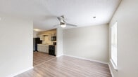 Located at 304 Fort Town Dr in Fort Oglethorpe, GA, this single-story unit offers a practical and comfortable layout across one floor. The open-concept kitchen and living area forms the heart of the home, featuring wood-look plank flooring, a textured ceiling, and a ceiling fan that enhances airflow throughout the space. The kitchen is outfitted with gray cabinetry, white countertops, a double-basin stainless steel sink, and black appliances including a refrigerator, electric range, and over-the-range microwave. Ample cabinet storage lines the walls, providing generous organization options. The living area flows naturally from the kitchen, brightened by a window that invites natural light. The bedroom is a well-proportioned retreat finished with plush carpeting, a ceiling fan with light fixture, a window with blinds offering outdoor views, and a closet for storage. The full bathroom features a single-sink vanity with gray cabinetry, a lighted mirror, and a tub-shower combination. A dedicated utility room rounds out the layout, adding functional storage and laundry space. Neutral tones and clean finishes throughout give the unit a bright, move-in-ready feel.