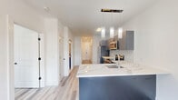 Located on William Street in Belleville, NJ, this well-appointed one-bedroom, one-bathroom unit offers a thoughtfully designed single-floor layout with modern finishes throughout. The open-concept living area is bathed in natural light through a large window framing neighborhood views, complemented by light-toned wood-style flooring and crisp white walls that create a clean, airy atmosphere.

The kitchen is a standout feature, showcasing sleek gray cabinetry, bright white countertops, a subway tile backsplash, and a full suite of stainless steel appliances including a refrigerator, range, microwave, and dishwasher. Pendant lighting above the counter adds a contemporary touch to the functional workspace.

The bedroom is a comfortable, well-proportioned room featuring the same light wood flooring, neutral white walls, and a window with an exterior view, providing a calm and restful environment. A dedicated closet offers practical storage.

The bathroom is finished with large-format earth-toned floor tiles, gray accent walls, and clean white fixtures, delivering a simple and functional space. Throughout the unit, black hardware accents on doors provide subtle modern contrast. The overall design emphasizes clean lines, neutral tones, and durable materials, making this a move-in ready home in Belleville, NJ.