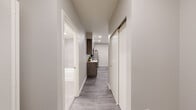 Located at 8445 Pacific Ave in Tacoma, Washington, this modern single-floor unit is part of a contemporary multi-building residential community with on-site parking. The interior showcases a cohesive neutral palette, recessed lighting, and durable wood-look tile flooring in the main living areas, complemented by plush carpet in the bedrooms.

The kitchen is a standout feature, equipped with sleek concrete-finish cabinetry, stainless steel appliances including a refrigerator, range, and over-the-range microwave, and a peninsula with a white quartz countertop and undermount sink — ideal for both cooking and casual dining. Adjacent to the kitchen, a dedicated dining area offers natural light through a window with blinds and provides comfortable space for a full dining set.

The living room is bright and welcoming, featuring a large window that fills the space with natural light. Two well-appointed bedrooms include recessed lighting, soft carpeting, and sliding-door closets for ample storage. An in-unit stacked washer and dryer adds everyday convenience. The bathroom is finished with large-format tile surround in the tub/shower, a white quartz vanity, and brushed nickel fixtures. A clean, well-lit hallway with a sliding storage closet connects all rooms efficiently.