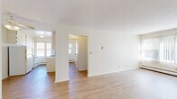Located at 2025 Ide St in Maplewood, MN, this single-floor, 2-bedroom, 2-bathroom residence offers a clean, bright layout with a neutral color palette throughout. The open living room is a standout feature, with large windows dressed in vertical blinds that invite abundant natural light and connect the interior to the outdoors. Light hardwood-style flooring runs through the living area, kitchen, and hallway, lending a cohesive and easy-to-maintain aesthetic.

The galley kitchen is efficiently designed, featuring white cabinetry lining both walls, ample overhead storage, a double sink, and a window above the counter that keeps the space well-lit. It opens directly toward the living room, maintaining an accessible flow between spaces.

Both bedrooms are carpeted and include ceiling fans, baseboard heating, and louvered bifold closet doors. The primary bedroom is generously sized and is complemented by an impressive wall of built-in closets, providing exceptional storage capacity, along with direct access to one of the two bathrooms. The second bedroom also offers a closet and window with natural light.

The bathrooms are finished with classic white tile, a vanity with mirror, and a bathtub, maintaining a clean and functional design. A dedicated entrance and hallway complete the well-organized floor plan of this comfortable Maplewood residence.