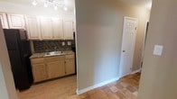 This single-floor space presents a clean, functional layout highlighted by warm, natural tones and practical finishes. The kitchen area is equipped with light wood cabinetry spanning both upper and lower sections, offering generous storage. A stainless steel sink is set into a granite-style countertop, complemented by a textured tile backsplash that adds visual interest to the cooking space. Track lighting mounted on the ceiling provides focused illumination across the kitchen workspace. Appliances, including what appears to be a range, are integrated seamlessly into the cabinetry layout. The flooring throughout is hardwood, lending warmth and continuity to the space. Neutral gray walls create a versatile backdrop that pairs well with the light wood tones of the cabinetry. A six-panel white door is visible from the main area, suggesting an additional room or closet nearby. White baseboards provide a crisp finishing detail along the walls. The overall ambiance is understated and practical, with a neutral palette that offers a blank canvas for personalization. The layout appears efficient, making good use of the available space on the single floor.