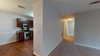 This single-floor residence offers a thoughtfully designed layout that balances comfort and functionality throughout. The kitchen is well-equipped with rich dark wood cabinetry, granite-style countertops, and a full suite of stainless steel appliances, including a gas range, built-in microwave, dishwasher, and refrigerator. Wood-look flooring grounds the kitchen and flows into the adjacent dining area, which is elevated by a stylish multi-arm chandelier and chair-rail molding along the walls, adding a refined architectural detail. The spacious living room features plush carpeting, a ceiling fan with light fixture, and windows that invite natural light, with a door providing direct exterior access. Two generously sized bedrooms continue the carpeted warmth, each outfitted with a ceiling fan and windows offering outdoor views, with one bedroom featuring a walk-in closet. Both full bathrooms are finished with light tile flooring, a vanity with storage, and a tub-shower combination. A dedicated laundry room houses a full-size washer and dryer alongside wire shelving and an electrical panel. Soft blue-gray paint throughout the home creates a calm, cohesive atmosphere from room to room.