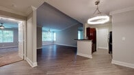 Located at 4116 Arbor Gates Dr NE in Atlanta, Georgia, this single-floor residence offers a well-designed, functional layout throughout. The open-concept living and dining area is anchored by rich hardwood-style flooring, white decorative columns, and crown molding that lend a classic architectural touch. A modern circular pendant light illuminates the entry, while multiple windows allow natural light to fill the space and offer views of the surrounding greenery.

The kitchen features rich dark wood cabinetry, dark granite countertops, and stainless steel appliances including a refrigerator and dishwasher, complemented by light hardwood-style flooring. A peninsula-style breakfast bar connects the kitchen to the main living area.

The bedrooms are finished with soft wall-to-wall carpeting, crown molding, and windows framing tree-lined outdoor views, creating a calm and comfortable atmosphere. A dedicated hallway connects the private areas of the residence.

Both bathrooms are finished with gray granite tile on the floors and walls, each featuring a classic pedestal sink and a large mirror, giving them a clean and timeless appearance. An in-unit laundry room provides added convenience, housing a full-size washer and dryer side by side on hardwood-style flooring with built-in shelving above.