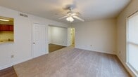 Located at 1901 Lipscomb Rd E in Wilson, NC, this single-floor unit features three bedrooms, one bathroom, and a combined kitchen and living room, all thoughtfully arranged along a central hallway. The kitchen is equipped with warm-toned wooden cabinetry, light countertops, a double-basin sink, a dishwasher, a refrigerator, and an electric range, all set atop durable wood-look flooring that extends through the main living areas. The living room is a comfortable, open space with neutral walls and carpet flooring, ceiling fan, and access to the rest of the unit. Each of the three bedrooms features plush carpet flooring, ceiling fans with light fixtures, and windows that allow natural light to filter in, offering views of the surrounding outdoor scenery. The primary bedroom is generously sized with ample floor space. The shared full bathroom includes a combination tub and shower, a toilet, and a pedestal sink, finished with wood-look tile flooring. Clean white walls and neutral tones throughout the unit create a bright, functional living environment suitable for a variety of occupants.