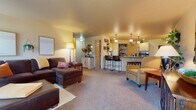 Located at 3910 Mount View Ave in Weston, Wisconsin, this single-floor unit offers a functional and comfortable layout with a warm, welcoming aesthetic. The exterior entrance is framed by brick construction, with a covered entryway that leads directly into the living space.

The open-concept main living area seamlessly connects the living room, dining space, and kitchen. The living room features plush carpeting, ample natural light, and a door providing direct access to a private patio. The kitchen is outfitted with light wood cabinetry, a dark granite-style countertop, a breakfast bar with seating, pendant lighting, recessed ceiling lights, and a dedicated walk-in pantry for generous storage. Adjacent to the kitchen, a cozy dining nook accommodates a round table beneath a chandelier, with tile flooring and a nearby closet.

The bedrooms are carpeted and well-sized, each with natural light from windows. One bedroom includes a ceiling fan, while another features warm-toned walls and ample dresser space. The bathroom offers a tub-shower combination, built-in shelving, a vanity with storage, and tile flooring. Throughout, the unit maintains a cohesive, neutral palette that creates a comfortable and inviting atmosphere.