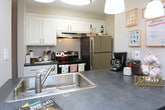 This single-floor residence at Bebout Drive in Norcross, Georgia, offers a thoughtfully arranged layout with distinct living, dining, kitchen, bedroom, and bathroom spaces. The living room serves as a welcoming central gathering area, featuring wood-style flooring, a textured ceiling, and a window that allows natural light to fill the room. The space flows naturally into the dining area, which is anchored by a pendant light fixture overhead and includes a closet for additional storage.

The galley-style kitchen is efficiently designed with white cabinetry, dark countertops, stainless steel appliances, and a double-basin sink. Its corridor layout connects directly to the dining area, creating a practical flow between cooking and eating spaces.

The residence includes multiple bedrooms, each carpeted for comfort and featuring windows that bring in natural light. One bedroom offers a walk-in closet with built-in shelving, while another provides generous wall space and room for a full suite of furniture.

The bathrooms are clean and well-finished, featuring white vanity cabinetry, large mirrors with overhead lighting, wood-style flooring, and neutral tones throughout, contributing to a cohesive and calm overall aesthetic.