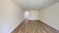 Located at 2930 Cherry St, Unit 201 in Falls Church, Virginia, this one-bedroom, one-bathroom residence offers a comfortable and functional layout across a generously sized single floor. The open living area is bright and welcoming, featuring warm hardwood-style flooring and large sliding glass doors that frame lush, tree-lined views while filling the space with natural light. The kitchen is well-appointed with white cabinetry, stainless steel appliances including a refrigerator and range, a dishwasher, and an in-unit stacked washer and dryer — all complemented by a peninsula counter that adds prep space and visual separation from the living area. The bedroom is a comfortable retreat with light wood flooring, a large window fitted with vertical blinds that provide both privacy and natural light, and access to a well-organized walk-in closet outfitted with wire shelving on both sides for ample storage. The bathroom features a full tub and shower combination with clean white tile surround and marble-style flooring. Neutral walls and consistent flooring throughout lend a cohesive, move-in-ready feel to this well-maintained Falls Church residence.