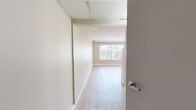 Located in San Diego, CA 92127, this studio offers a practical and efficiently designed single-floor layout. The main living area is finished with warm, light-toned wood flooring that extends throughout, creating a cohesive and clean aesthetic. Neutral beige walls and a textured ceiling complement the open feel of the space. A large window allows natural light to fill the room while offering views of the surrounding neighborhood, and a wall-mounted mini-split air conditioning unit ensures year-round comfort.

The kitchenette is neatly integrated into the living space, featuring white cabinetry, a compact sink, under-counter refrigerator, and a microwave — providing all the essential cooking and storage needs in a streamlined footprint. An entry door is conveniently positioned adjacent to the kitchenette area.

The bathroom is well-appointed with accessibility in mind, showcasing light tile flooring, a granite-topped vanity with a framed mirror, a wall-mounted medicine cabinet with glass shelving, and stainless steel grab bars near the toilet and shower area. The open vanity design further enhances accessibility. Overall, this studio delivers a functional and comfortable living environment ideal for those seeking an efficient space in San Diego.