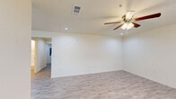 Located at 7901 Heatherbrook Trail in Port Arthur, Texas, this single-story 1-bedroom, 1-bathroom home offers a clean, modern aesthetic with thoughtful finishes throughout. The combined kitchen and living area serves as the heart of the home, featuring light wood-look tile flooring, recessed lighting, and a ceiling fan. The kitchen is equipped with crisp white cabinetry, gray countertops, a stainless steel sink, and black appliances including a refrigerator, electric range, and microwave — all complemented by a window that brings in natural light. The living area flows seamlessly from the kitchen, providing an open and connected feel. The generously sized bedroom is finished with plush carpet, a ceiling fan, a window with blinds, and access to a dedicated closet. The bathroom features a gray vanity with ample drawer and cabinet storage, a large mirror with a lighted bar fixture, and wood-look tile flooring. A dedicated laundry room includes upper white cabinetry and hookups for a washer and dryer. The hallway connects all rooms efficiently, completing this well-organized and move-in-ready home.