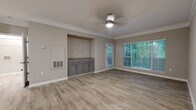 Located at 9200 Robert Dr. in Sandy Springs, GA, this single-floor residence offers a well-designed layout with consistent finishes throughout. The main living area features light wood-look luxury vinyl flooring, neutral warm-gray walls, crown molding, and a ceiling fan with light fixture. Large windows fitted with horizontal blinds frame peaceful views of the surrounding wooded greenery, filling the space with natural light. A built-in recessed cabinetry nook with granite countertops provides a convenient dry bar or workstation area within the living space.

The kitchen is appointed with gray shaker-style cabinetry, granite countertops, a subway tile backsplash, an undermount sink with a modern pull-down faucet, and black stainless appliances including a refrigerator and range.

The bedrooms are carpeted for comfort and include ceiling fans, ample natural light from large windows with wooded outlooks, and access to closet space. The bathroom features a double-sink vanity with granite countertops and gray cabinetry, a large framed mirror, and a shower/tub combination. The cohesive neutral palette and updated finishes throughout create a clean, modern, and comfortable living environment.