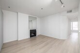This 800 square foot apartment in Los Angeles offers a thoughtful layout maximizing space and functionality. The single-floor plan includes a generously sized 230 square foot primary bedroom, providing ample living space. The open concept design seamlessly integrates the kitchen and living room, creating a spacious feel throughout.

The living area is anchored by a sleek fireplace, adding both warmth and a focal point to the room. Large windows and a balcony access point flood the space with natural light, enhancing the apartment's airy ambiance. Light wood flooring runs throughout, unifying the design and adding a modern touch.

The updated kitchen boasts white cabinetry, contrasting dark granite countertops, and stainless steel appliances. A skylight above brings additional brightness to the cooking space. The U-shaped layout offers efficient workflow and plenty of storage.

A dedicated closet area provides valuable storage space, while the bathroom, though not pictured, likely continues the apartment's modern aesthetic. The neutral color palette throughout allows for versatile decorating options, making this apartment a blank canvas for personal style.