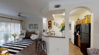 Located in Houston, TX, this single-story residence offers a thoughtfully designed open-concept layout finished with warm wood-look flooring throughout the main living areas. The living room connects seamlessly to the dining area, which is distinguished by crown molding, a pendant light fixture, and chair-rail detailing. A peninsula-style breakfast bar with bar seating bridges the kitchen and living spaces, framed by an elegant arched passageway. The kitchen is equipped with warm wood cabinetry, black appliances including a refrigerator and microwave, and direct access to a dedicated in-unit laundry room housing a full-size washer and dryer with overhead shelving.

The bedrooms are generously proportioned, each featuring wood-look flooring, large windows that invite natural light, and access to walk-in closets with built-in hanging rods. The bathrooms are finished with tile flooring, warm wood vanity cabinetry, countertop sinks, and tub-shower combinations. Throughout the home, a neutral warm-beige color palette creates a cohesive and inviting ambiance, while ceiling-height walls and well-placed lighting contribute to an open, airy atmosphere.