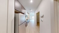 Located at 13023 Hema Dr in Austin, TX, this one-bedroom, one-bathroom unit offers a thoughtfully designed single-floor layout with contemporary finishes throughout. Light wood-style flooring flows seamlessly across the entire space, creating a cohesive and clean aesthetic.

The kitchen is a standout feature, outfitted with stainless steel appliances including a range, microwave, refrigerator, and dishwasher. White upper cabinetry contrasts neatly with dark wood lower cabinets, while a white quartz countertop and subway tile backsplash add a modern, polished touch. A stainless steel sink with a contemporary faucet completes the functional workspace. The kitchen opens toward the living area, which benefits from a sliding glass door that brings in natural light and provides outdoor views.

The bedroom is a comfortable, well-proportioned retreat featuring a sliding panel closet door that reveals built-in wire shelving and a hanging rod for organized storage.

The bathroom is clean and minimalist in design, featuring light wood-style flooring, a white vanity with dark lower cabinetry, a toilet, and a full bathtub with a shower combo equipped with a curved rod. Crisp white walls and recessed lighting keep the space feeling bright and open.

Overall, this unit delivers a modern, functional living environment with consistent design choices and practical amenities throughout.